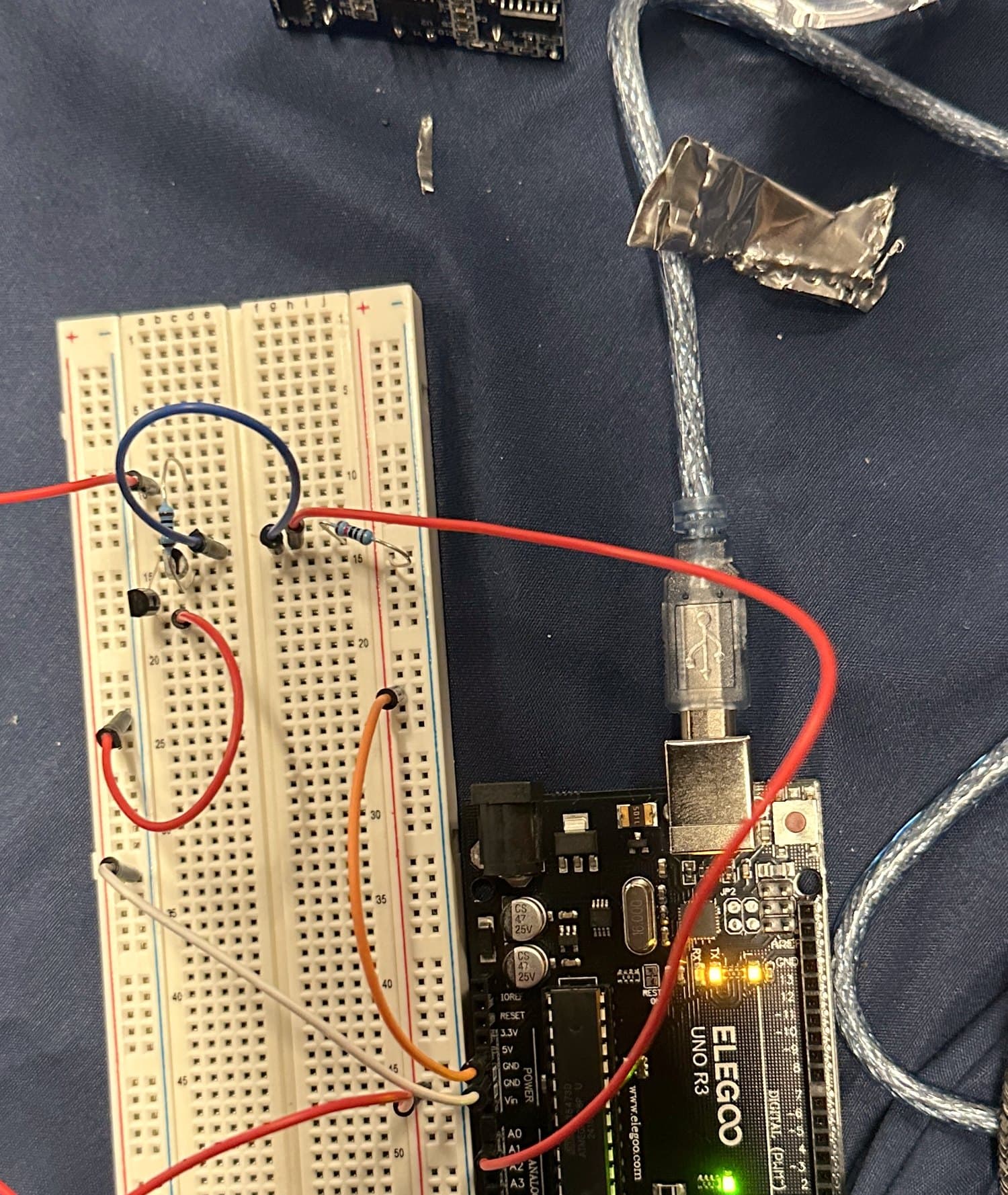 Arduino UNO, breadboard and probe on a bench